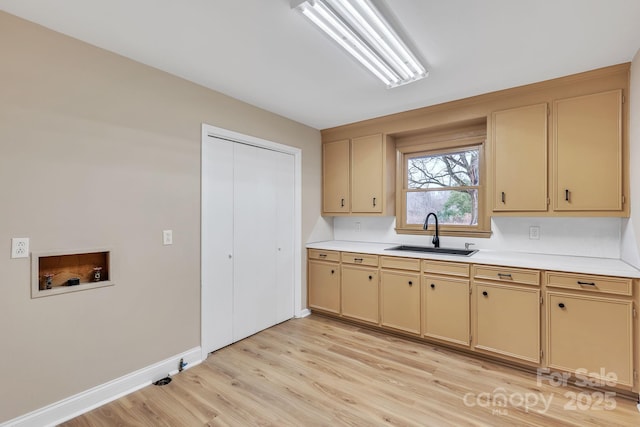 kitchen with sink, light brown cabinets, and light wood-type flooring