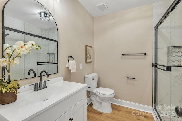 bathroom with vanity, hardwood / wood-style flooring, a shower with shower door, and toilet