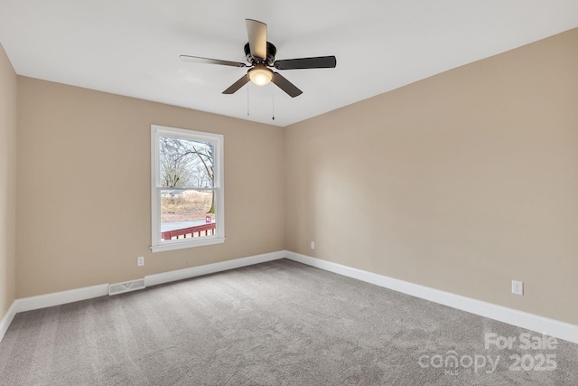 empty room featuring ceiling fan and carpet