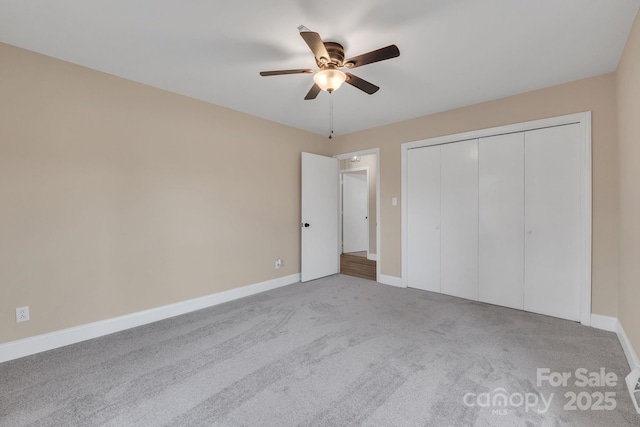 unfurnished bedroom featuring light colored carpet, a closet, and ceiling fan