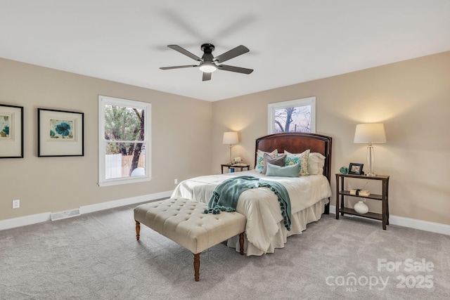 carpeted bedroom with multiple windows and ceiling fan