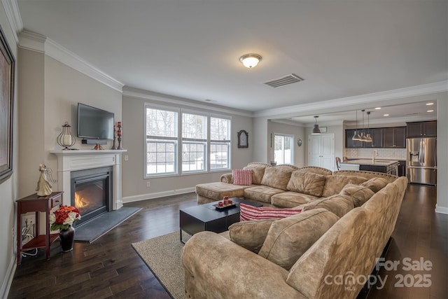 living room featuring dark wood-type flooring and ornamental molding