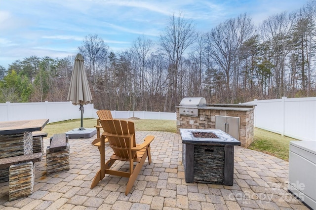 view of patio / terrace featuring area for grilling, an outdoor fire pit, and exterior kitchen