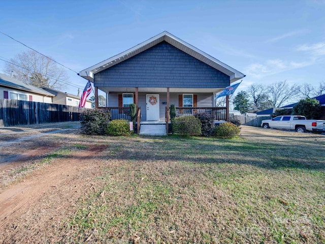 bungalow-style home featuring covered porch and a front lawn