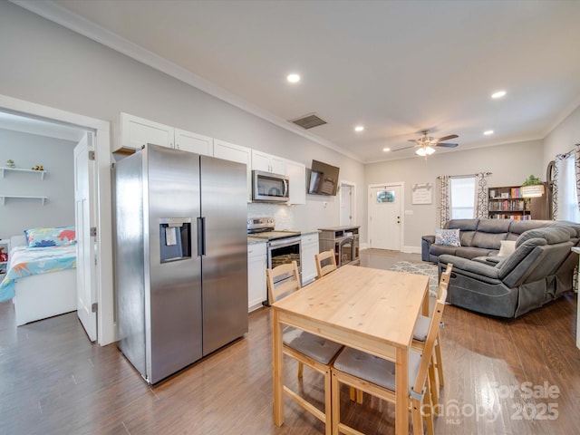 kitchen featuring stainless steel appliances, hardwood / wood-style flooring, and white cabinets