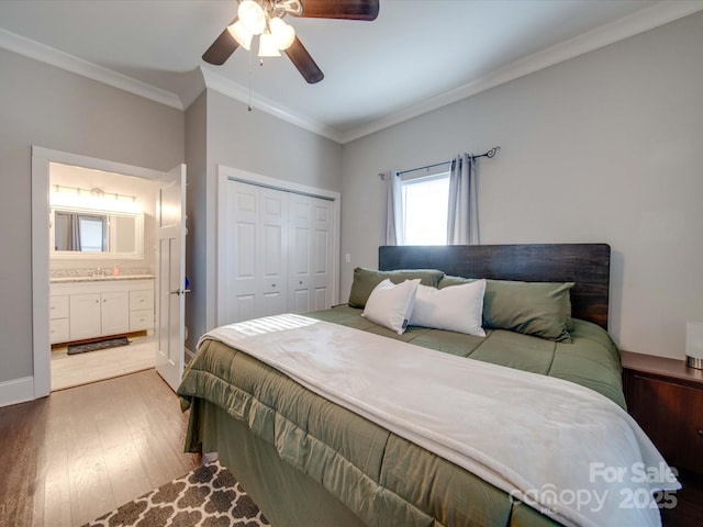 bedroom featuring connected bathroom, ornamental molding, a closet, hardwood / wood-style flooring, and ceiling fan