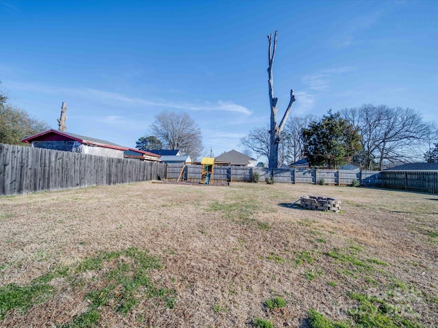 view of yard with a playground and a fire pit