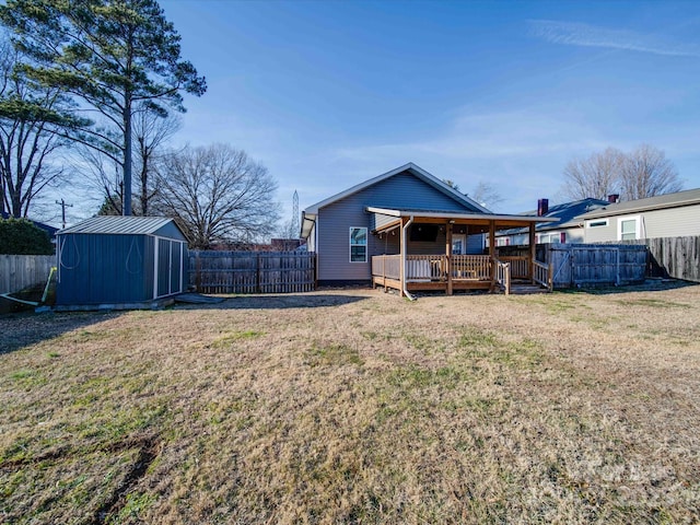 rear view of property with a yard, a deck, and a shed