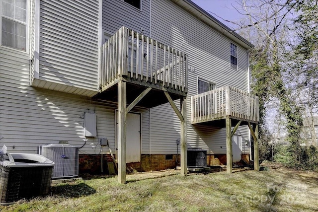 back of property featuring a lawn, a balcony, and central air condition unit