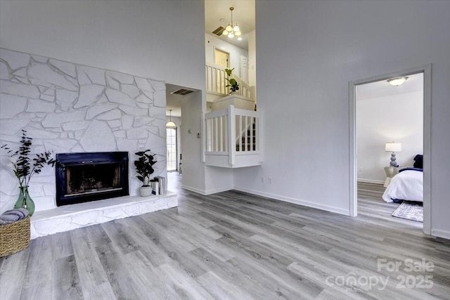 living room featuring a high ceiling, a fireplace, and light hardwood / wood-style flooring