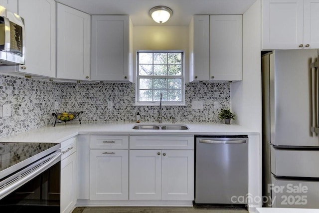 kitchen featuring stainless steel appliances, tasteful backsplash, sink, and white cabinets