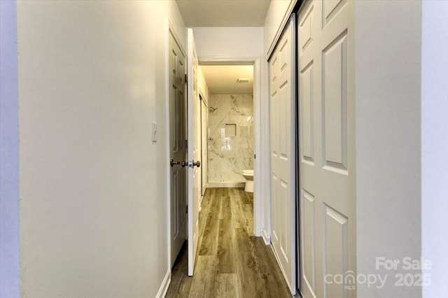 corridor with hardwood / wood-style flooring