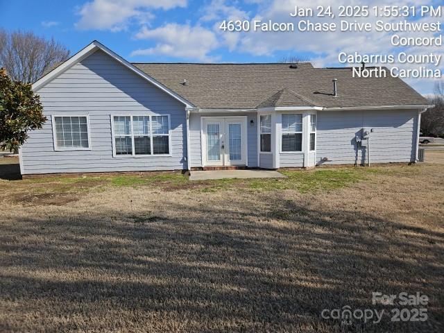 back of property with a yard and french doors