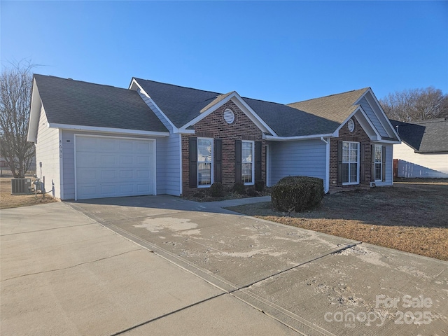 ranch-style house featuring central AC unit and a garage