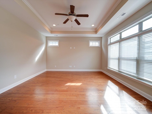 unfurnished room featuring crown molding, ceiling fan, a raised ceiling, and light hardwood / wood-style floors