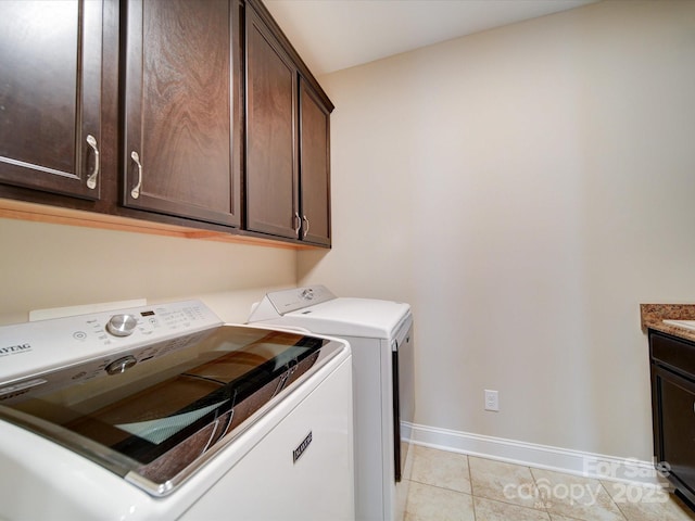 washroom with cabinets, light tile patterned flooring, and separate washer and dryer