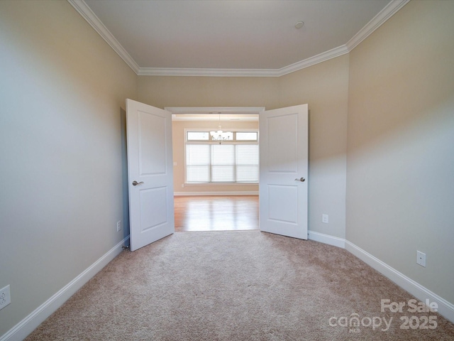 spare room with crown molding, an inviting chandelier, and light carpet