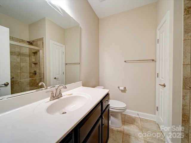 bathroom featuring tile patterned flooring, vanity, walk in shower, and toilet