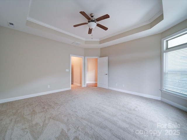 spare room with light carpet, a tray ceiling, and ornamental molding