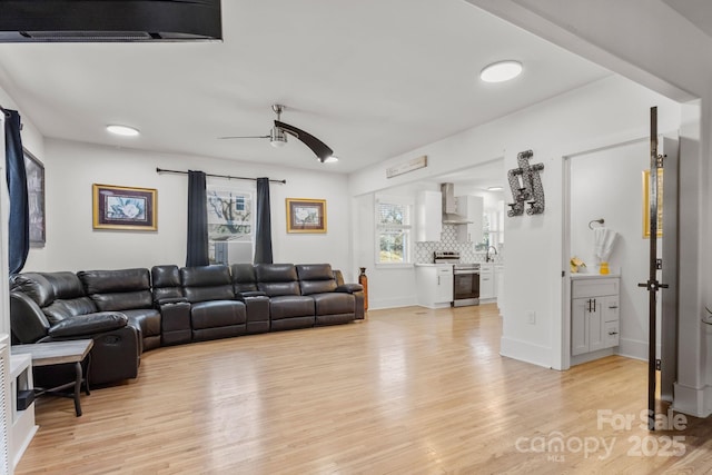 living room with sink, ceiling fan, and light hardwood / wood-style flooring