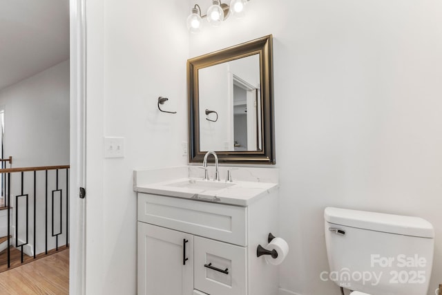 bathroom featuring hardwood / wood-style flooring, vanity, and toilet