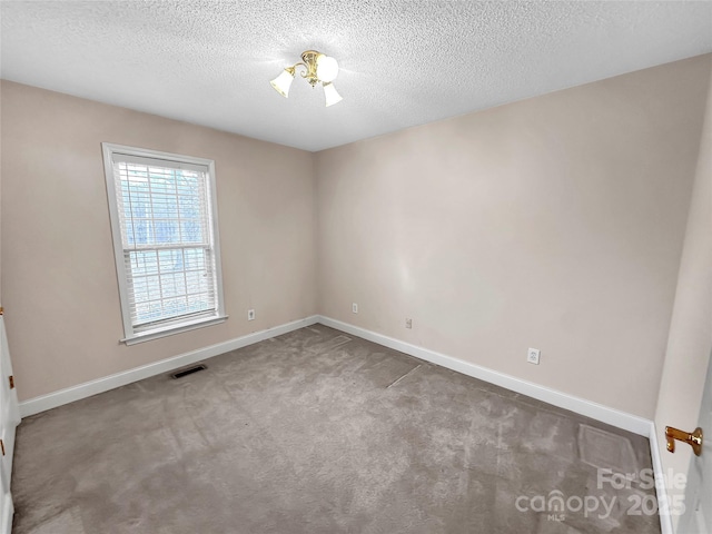 spare room with carpet floors and a textured ceiling