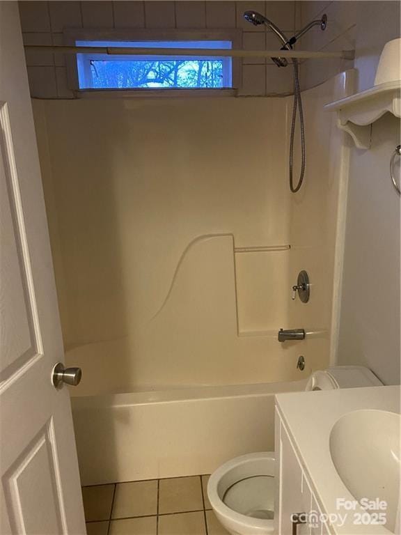 full bathroom with tile patterned flooring, vanity, tiled shower / bath combo, and toilet