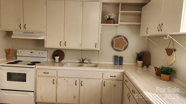 kitchen with tile counters, electric stove, a sink, and under cabinet range hood