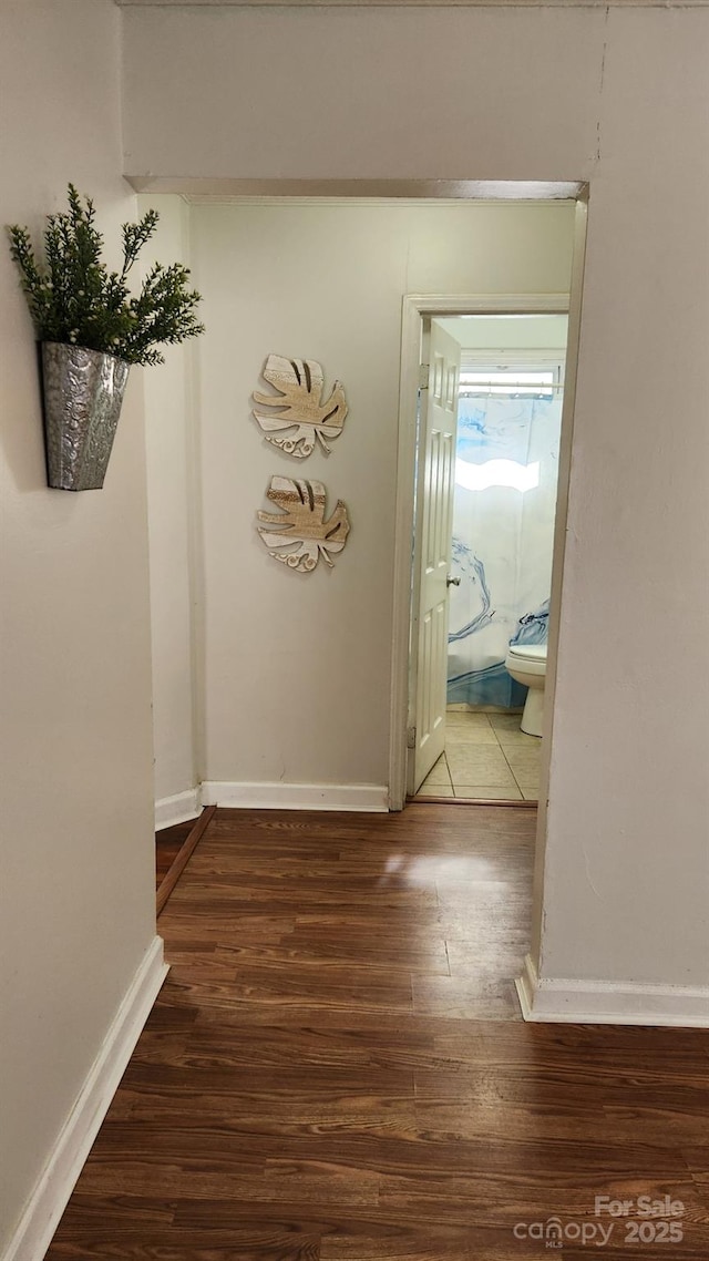 hall with dark wood-type flooring and baseboards