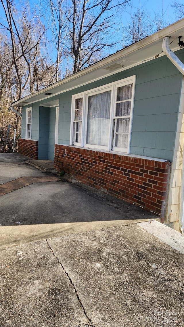 exterior space with aphalt driveway and brick siding