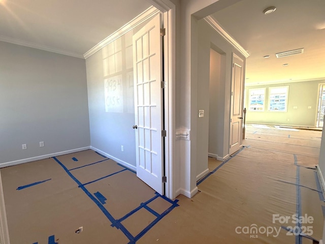 hallway with ornamental molding, visible vents, and baseboards