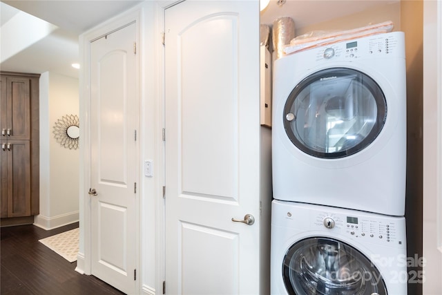 washroom with stacked washer and dryer and dark wood-type flooring