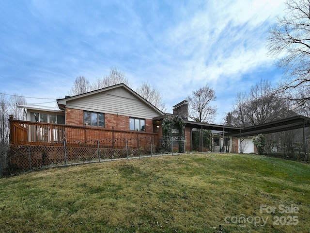 back of property featuring a wooden deck, a carport, and a yard