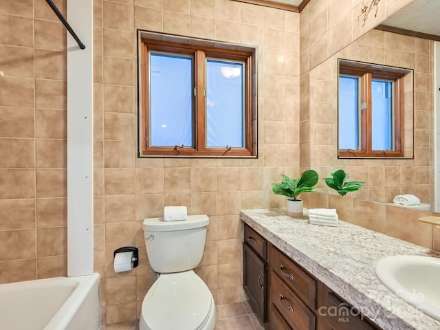 bathroom with vanity, toilet, and tile walls