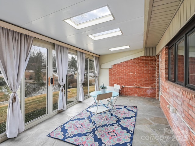 sunroom / solarium with vaulted ceiling with skylight