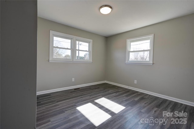 unfurnished room with plenty of natural light and dark wood-type flooring