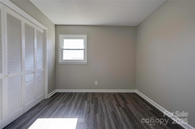 unfurnished bedroom featuring dark wood-type flooring and a closet