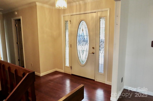 foyer entrance featuring dark wood-type flooring, crown molding, and a notable chandelier