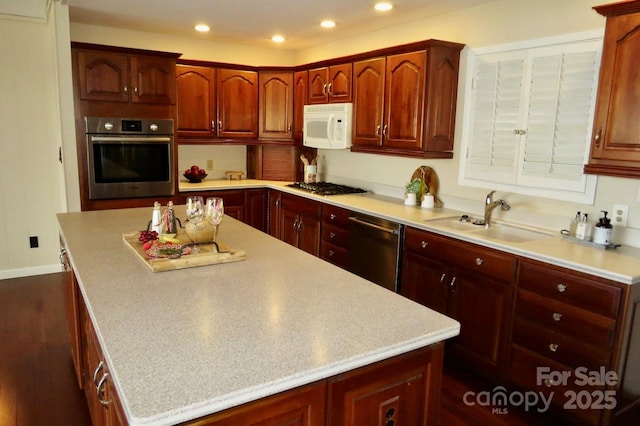 kitchen featuring dark hardwood / wood-style flooring, sink, stainless steel appliances, and a kitchen island