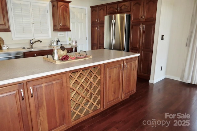 kitchen featuring appliances with stainless steel finishes, dark hardwood / wood-style flooring, and sink