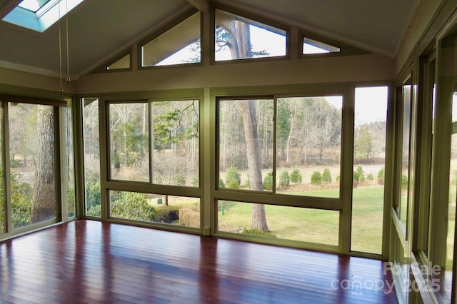 unfurnished sunroom with vaulted ceiling with skylight