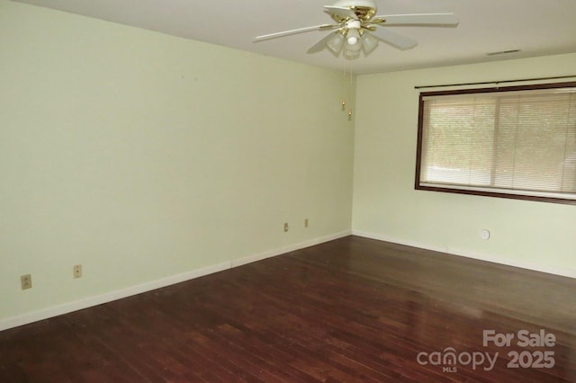 spare room featuring dark wood-type flooring and ceiling fan