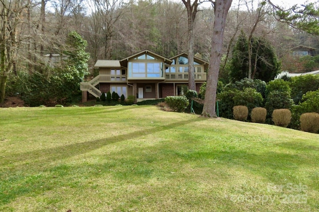 front facade with a wooden deck and a front yard