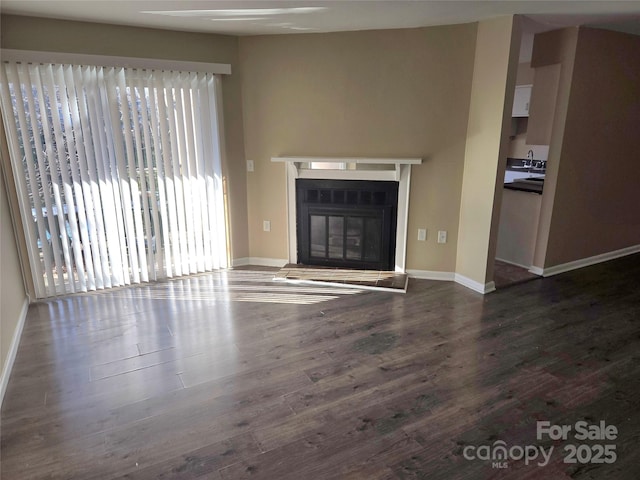 unfurnished living room with sink and dark hardwood / wood-style floors