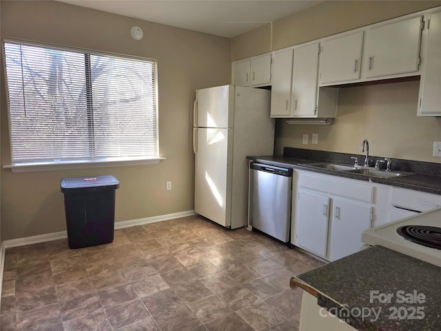 kitchen featuring dishwasher, sink, white fridge, and white cabinets