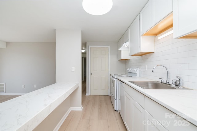 kitchen featuring sink, decorative backsplash, white electric stove, and white cabinets