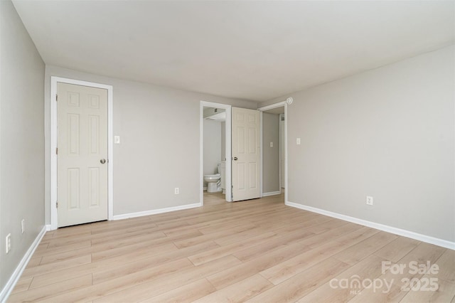 unfurnished bedroom with ensuite bathroom and light wood-type flooring