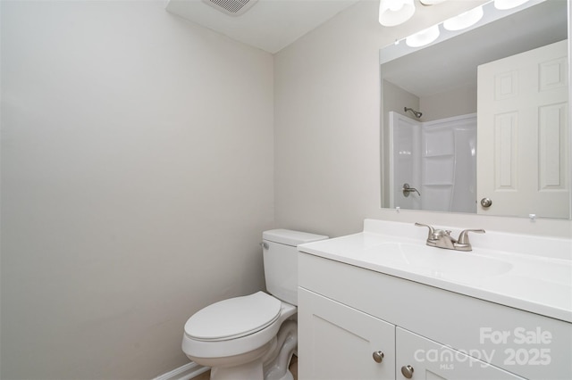 bathroom featuring vanity, a shower, and toilet