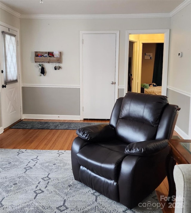 sitting room featuring wood-type flooring and ornamental molding