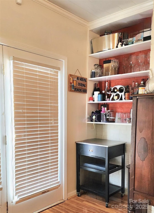 bar with crown molding and light hardwood / wood-style flooring